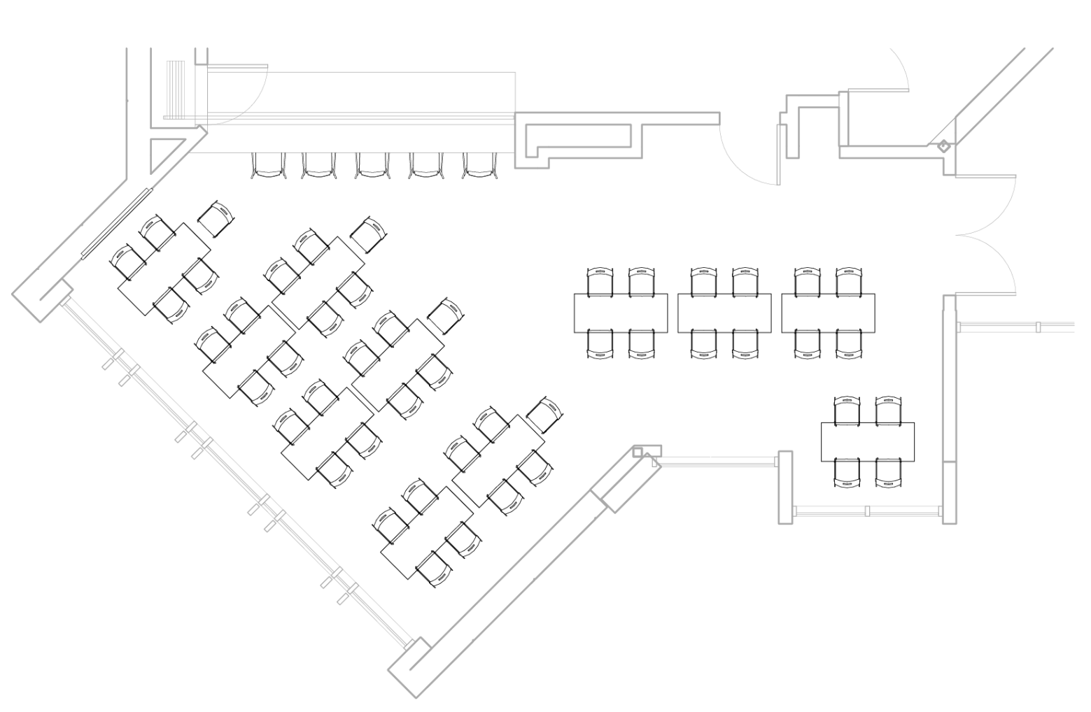 A room with an angled wall and eleven tables.