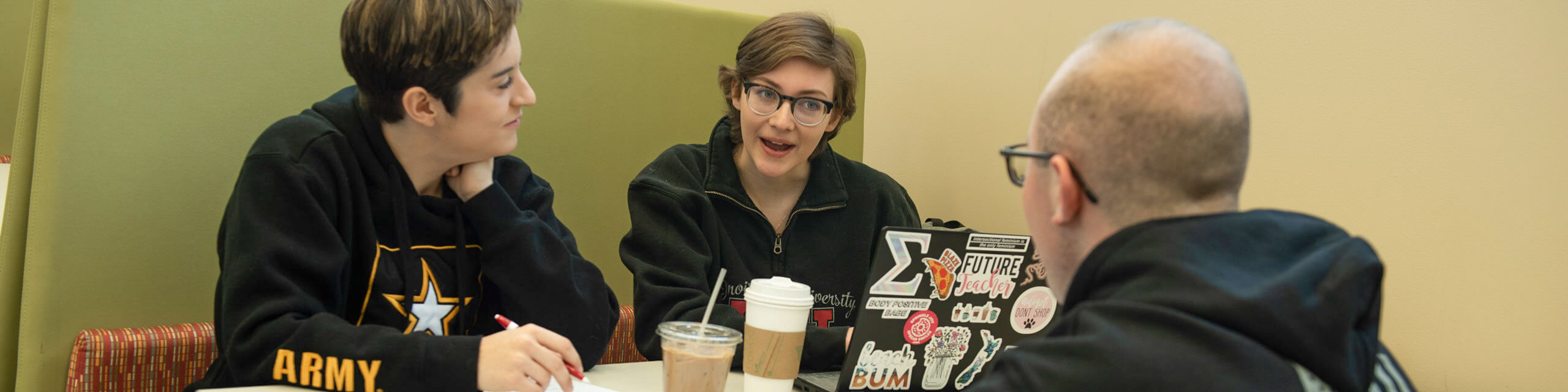 Students drink coffee in the library.